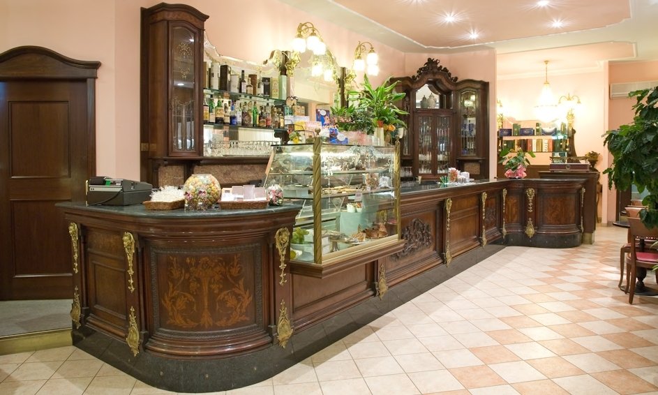 Il bancone storico in legno intarsiato della Pasticceria Barberis